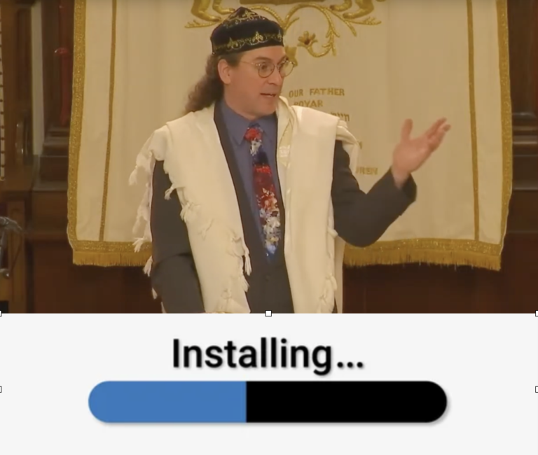 Reb Josh gesturing from the bima with a software "installing" bar under the image.
